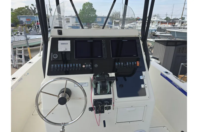 Slide: The Image of 2002 Sport-Craft Seacat 255 boat dashboard with steering wheel and navigation controls. - 9