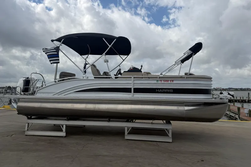 The Image of 2022 Harris FloteBote Solstice 250 pontoon boat docked under cloudy sky. - 1