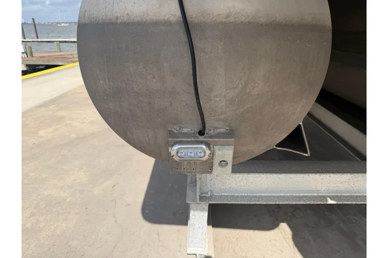 Slide: The Image of Rear view of 2022 Harris FloteBote Solstice 250 pontoon with visible wiring and dock background. - 21