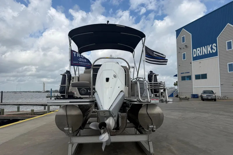 Slide: The Image of 2022 Harris FloteBote Solstice 250 pontoon boat docked near waterfront building. - 3