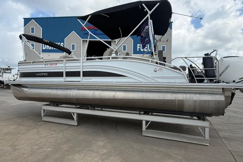 Slide: The Image of 2022 Harris FloteBote Solstice 250 pontoon boat on display at a marina. - 5