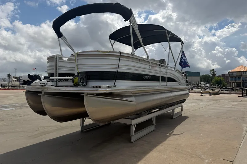 Slide: The Image of 2022 Harris FloteBote Solstice 250 pontoon boat on display under cloudy sky. - 7