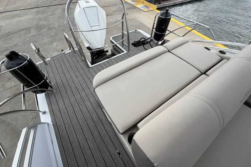 Slide: The Image of 2022 Harris FloteBote Solstice 250 boat deck with seating and motor at dockside. - 9