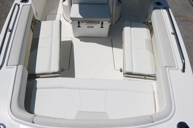 Slide: The Image of 2026 World Cat 235 TE boat interior with white cushioned seating and Yeti cooler. - 8