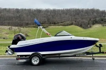 Slide: The Image of 2020 Tahoe 450 TF boat on trailer, parked outdoors with scenic background. - 3