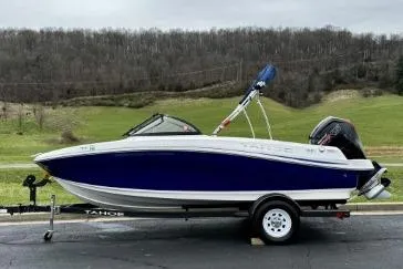 Slide: The Image of 2020 Tahoe 450 TF boat on trailer, parked outdoors with scenic background. - 5