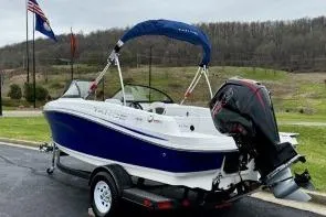 Slide: The Image of 2020 Tahoe 450 TF boat on trailer, blue and white design, parked outdoors. - 6