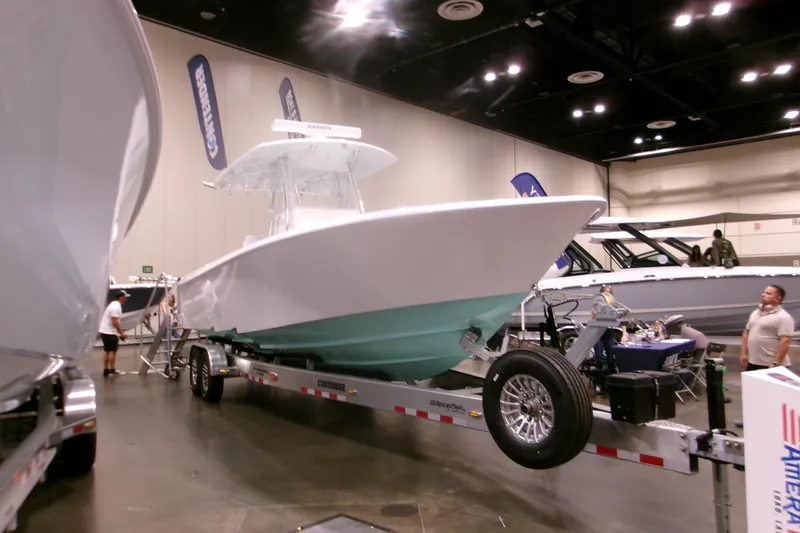 Slide: The Image of 2026 Contender 32 ST boat displayed indoors on a trailer at a boat show. - 1