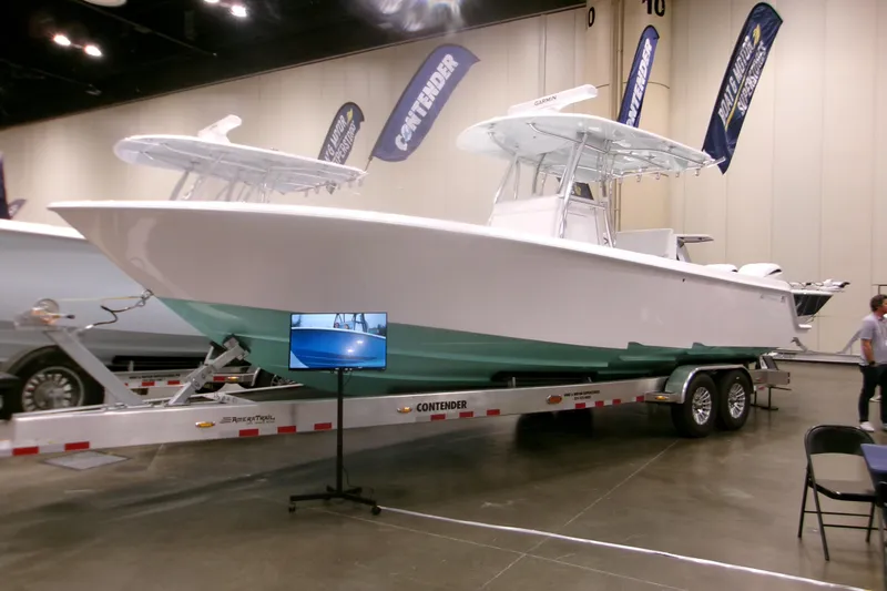 Slide: The Image of 2026 Contender 32 ST boat displayed indoors on a trailer at a boat show. - 2