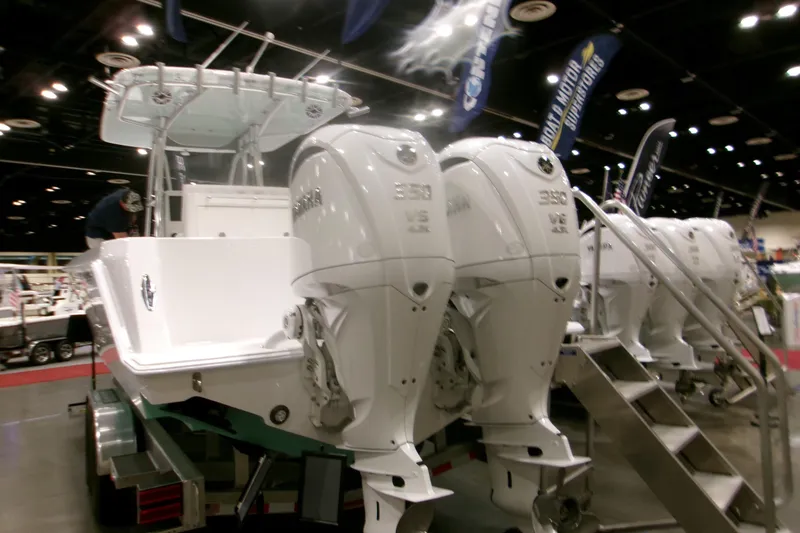 Slide: The Image of 2026 Contender 32 ST boat with dual outboard engines displayed at a boat show. - 21