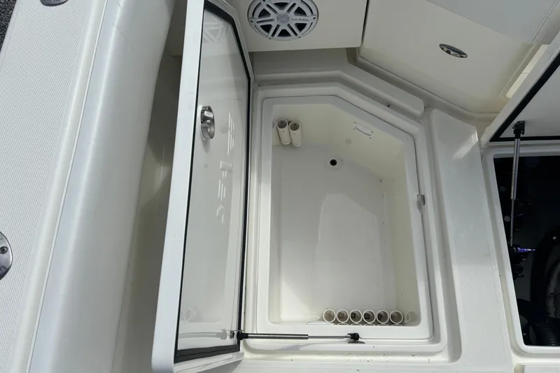 Slide: The Image of Open storage compartment on 2018 SeaVee 390Z boat, featuring rod holders and speaker. - 13