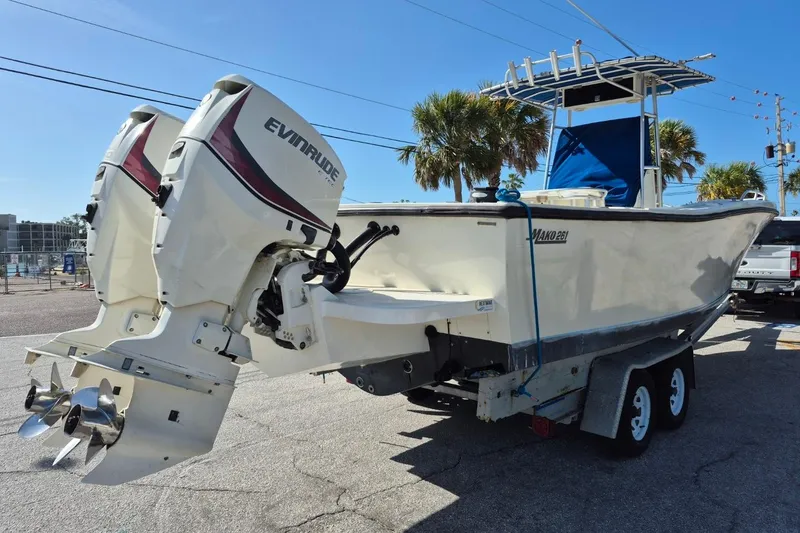 Slide: The Image of 1987 Mako 261 Center Console boat with dual Evinrude engines on a trailer. - 12