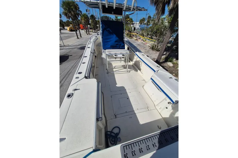 Slide: The Image of 1987 Mako 261 Center Console boat with spacious deck and seating, parked outdoors. - 13