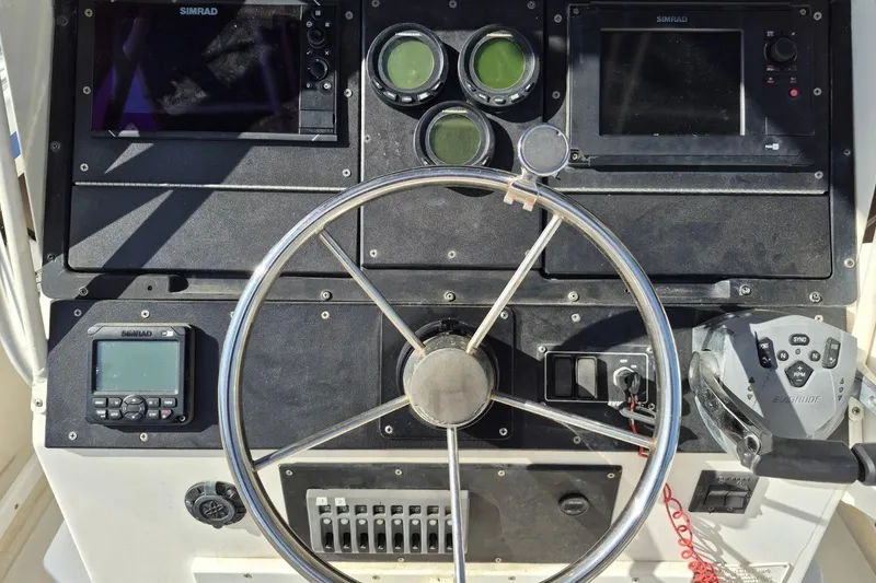 Slide: The Image of 1987 Mako 261 Center Console dashboard with steering wheel and navigation instruments. - 17