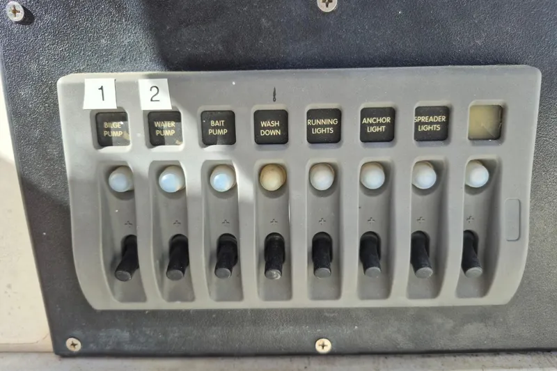 Slide: The Image of Control panel of a 1987 Mako 261 Center Console boat with labeled switches. - 22