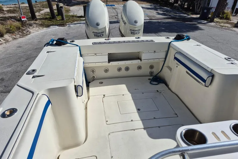 Slide: The Image of 1987 Mako 261 Center Console boat with dual Evinrude 150 engines, docked near the shore. - 24