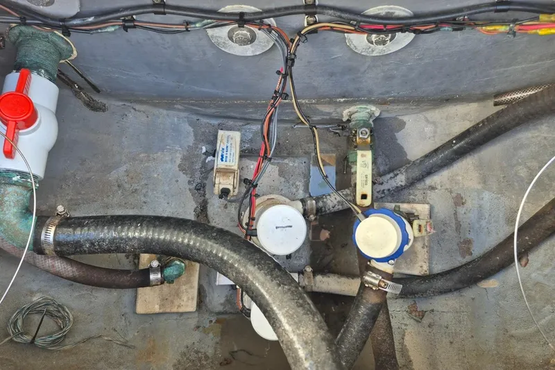 Slide: The Image of 1987 Mako 261 Center Console boat wiring and plumbing components in the hull. - 25