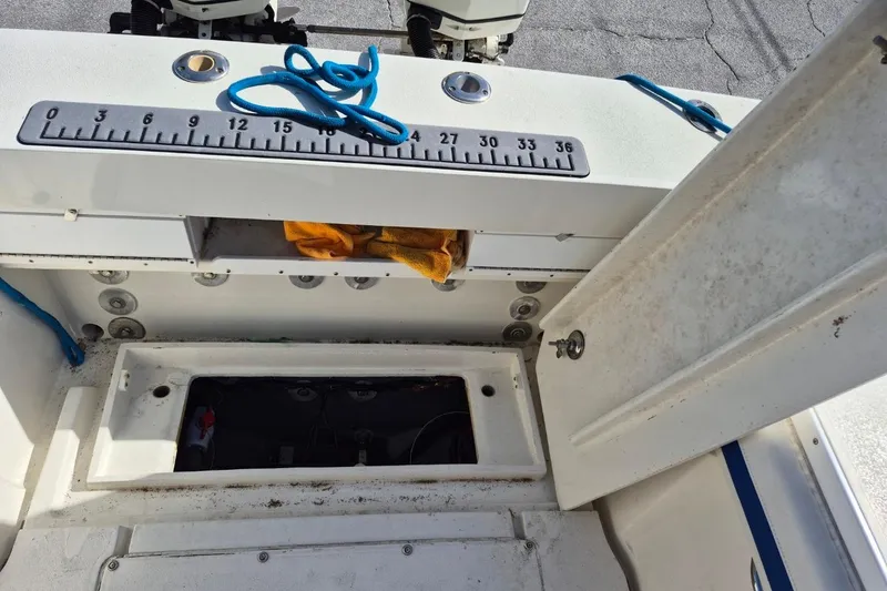 Slide: The Image of 1987 Mako 261 Center Console boat interior with open storage compartments and measuring ruler. - 26