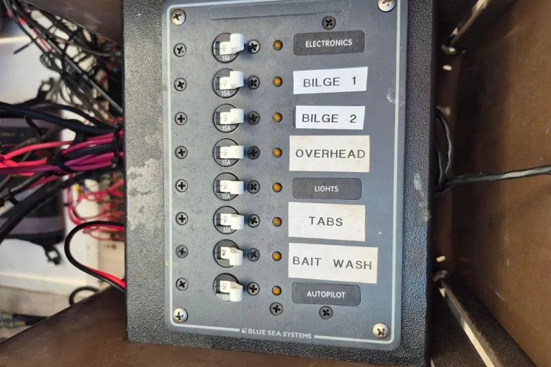 Slide: The Image of Control panel of a 1987 Mako 261 Center Console boat with labeled switches. - 37