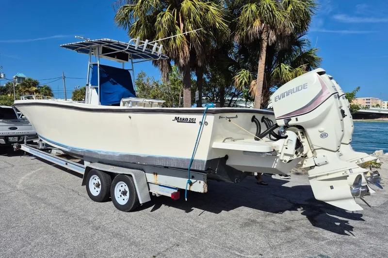 Slide: The Image of 1987 Mako 261 Center Console boat on trailer, featuring Evinrude outboard motor, parked near palm trees. - 4