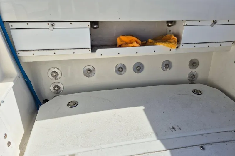 Slide: The Image of 1987 Mako 261 Center Console boat interior with storage compartments and yellow towel. - 45