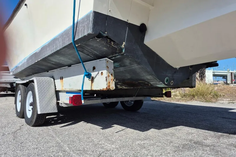 Slide: The Image of 1987 Mako 261 Center Console boat on trailer, showing hull and dual axles. - 5