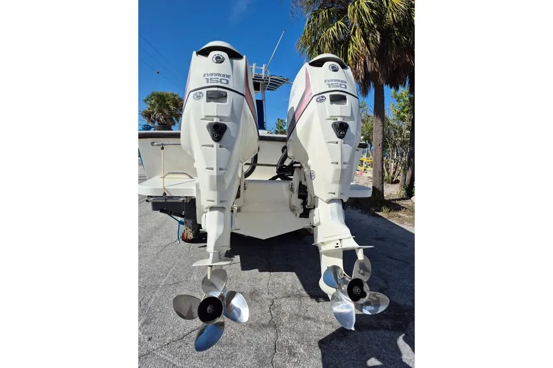 Slide: The Image of 1987 Mako 261 Center Console with dual Evinrude 150 outboard motors, parked outdoors. - 8