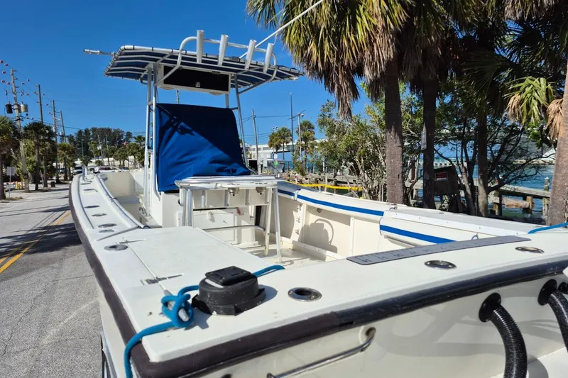 Slide: The Image of 1987 Mako 261 Center Console boat parked near palm trees and waterfront. - 9