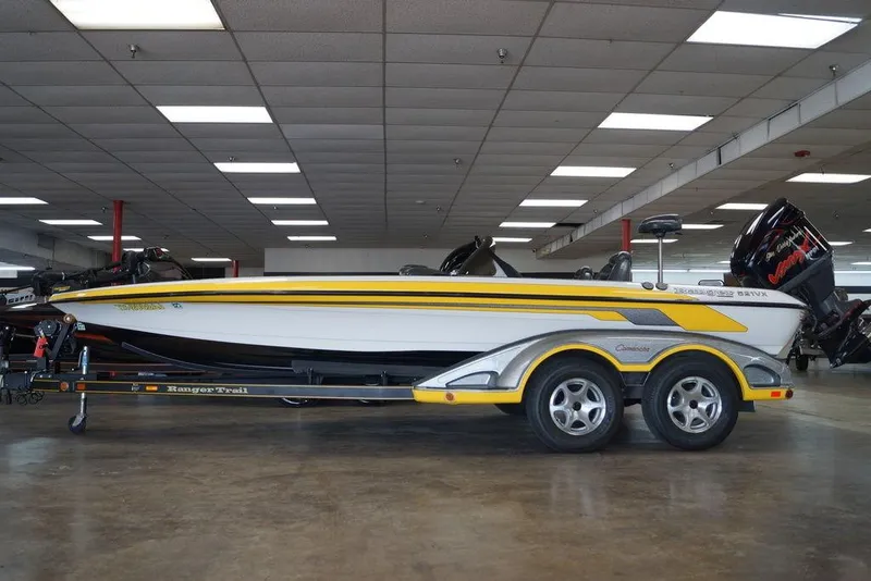 The Image of 2006 Ranger 521 VX boat with trailer, displayed indoors, featuring yellow and white design. - 0