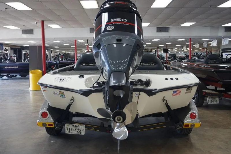 Slide: The Image of 2006 Ranger 521 VX boat with powerful motor, displayed indoors, showcasing sleek design and American flag. - 2