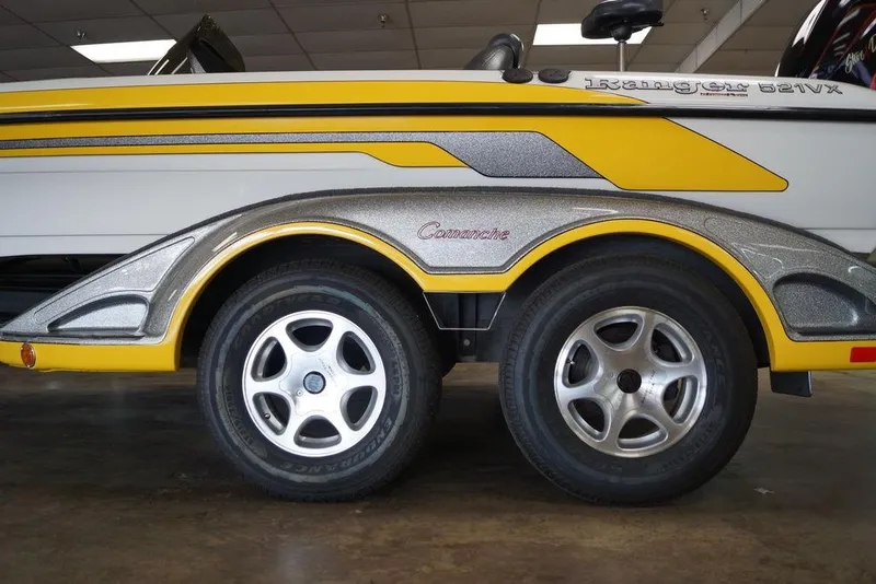 Slide: The Image of 2006 Ranger 521 VX boat trailer with yellow and silver detailing, featuring dual wheels. - 4