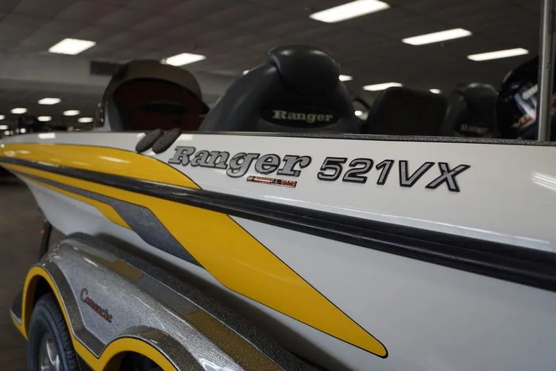 Slide: The Image of 2006 Ranger 521 VX boat with yellow and white design in showroom. - 6