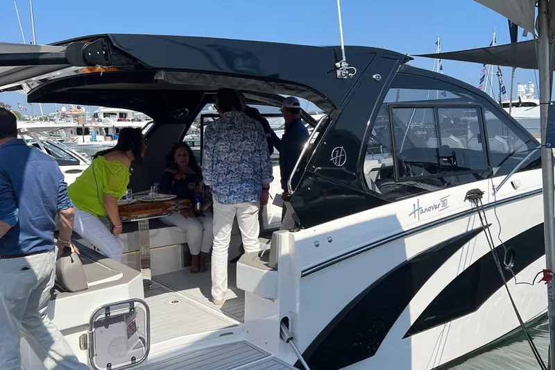 Slide: The Image of People socializing on a 2025 Hanover 387 yacht at a marina. - 16