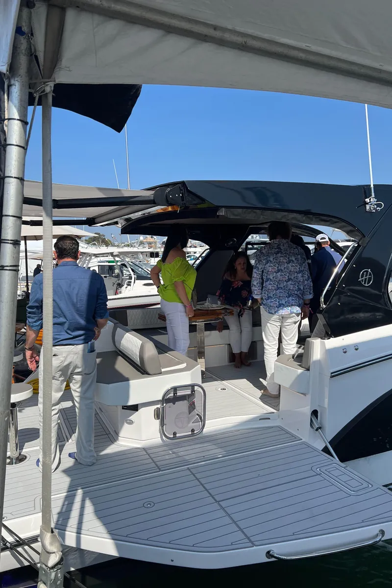 Slide: The Image of People socializing on a 2025 Hanover 387 yacht at a marina. - 17