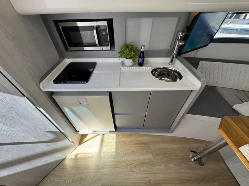 Slide: The Image of Compact kitchen in 2025 Hanover 387 RV with microwave, sink, and fridge. - 3