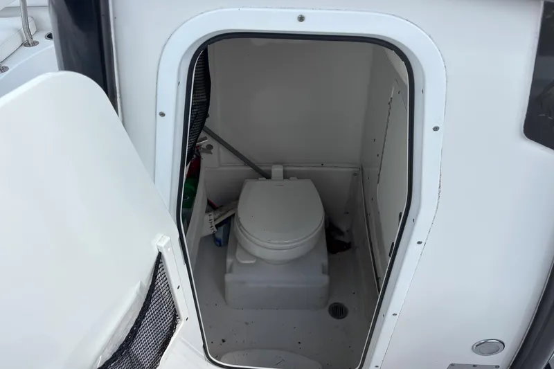 Slide: The Image of 2018 Sea Hunt Gamefish 27 boat interior with compact marine toilet. - 10