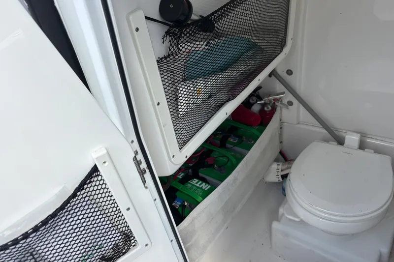 Slide: The Image of Interior of 2018 Sea Hunt Gamefish 27, featuring storage and marine toilet. - 11