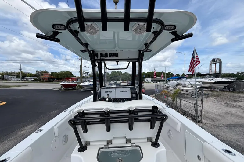 Slide: The Image of 2018 Sea Hunt Gamefish 27 boat with forward seating, displayed outdoors with American flags. - 25