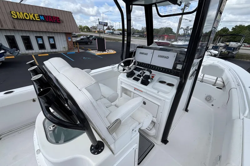 Slide: The Image of 2018 Sea Hunt Gamefish 27 boat interior with Simrad electronics, near a Smoke N Vape store. - 26