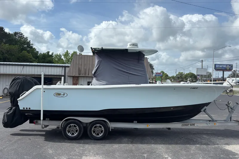 Slide: The Image of 2018 Sea Hunt Gamefish 27 boat on trailer, parked outdoors under cloudy sky. - 3
