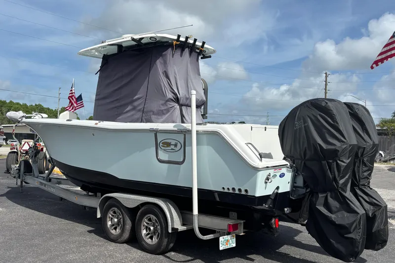 Slide: The Image of 2018 Sea Hunt Gamefish 27 boat on trailer, covered engines, American flags visible. - 4