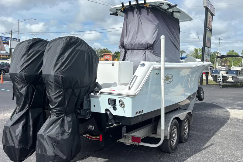 Slide: The Image of 2018 Sea Hunt Gamefish 27 boat on trailer with covered engines, parked outdoors. - 6