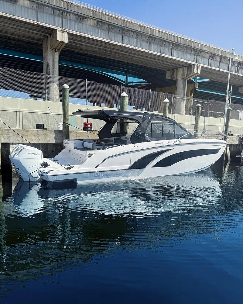 Slide: The Image of 2025 Hanover 387 boat docked under a bridge, reflecting on calm water. - 15