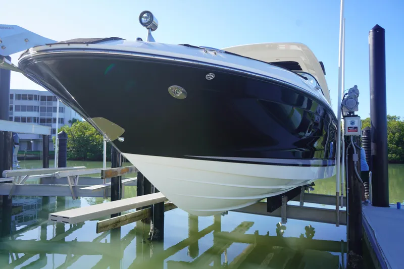 Slide: The Image of 2023 Sea Ray SLX 350 boat docked, showcasing sleek black and white hull design. - 7