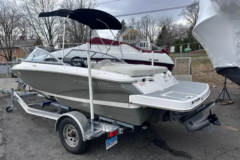 Slide: The Image of 2018 Regal 1900 ES Bowrider on trailer, parked outdoors with cover and canopy. - 1