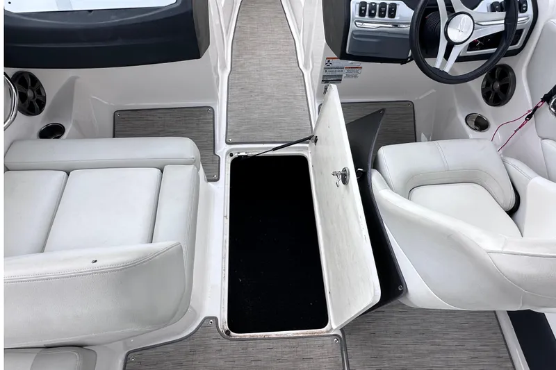 Slide: The Image of 2018 Regal 1900 ES Bowrider interior with open storage compartment and steering wheel. - 16