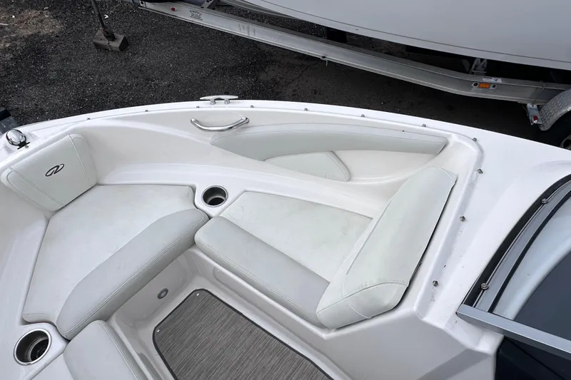 Slide: The Image of 2018 Regal 1900 ES Bowrider boat interior with white seating and cup holders. - 19