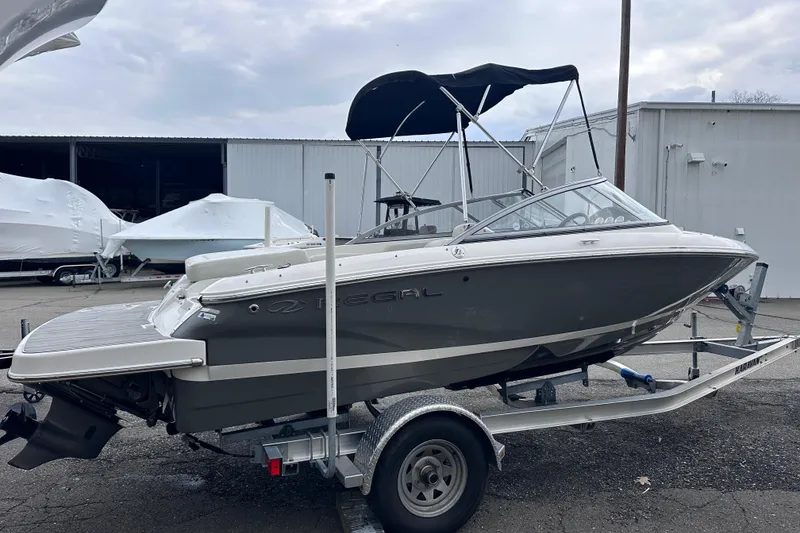 Slide: The Image of 2018 Regal 1900 ES Bowrider on trailer, gray hull, parked outdoors. - 3