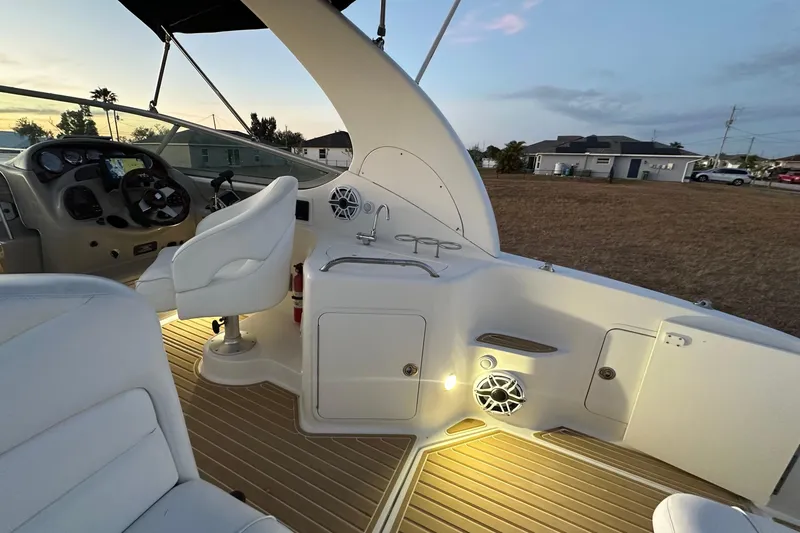 Slide: The Image of 2007 Sea Ray Sundancer 280 cockpit with helm, seating, and illuminated deck at sunset. - 17