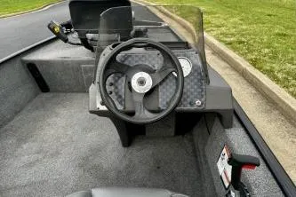 Slide: The Image of 2024 Tracker Bass Tracker Classic XL boat cockpit with steering wheel and dashboard controls. - 5